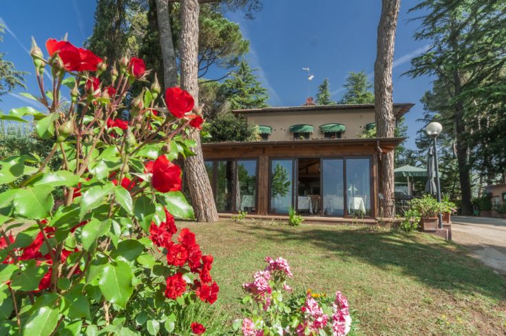 Hotel overlooking Lake Trasimeno, featuring a transformed villa with contemporary comforts and lush gardens.