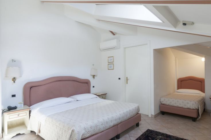 Simple hotel room with double beds and air conditioning, perfect for relaxation.
