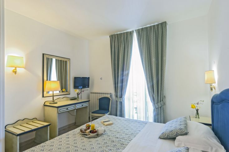 Comfortable and bright hotel room with modern furnishings, perfect for a relaxing stay by the lake.