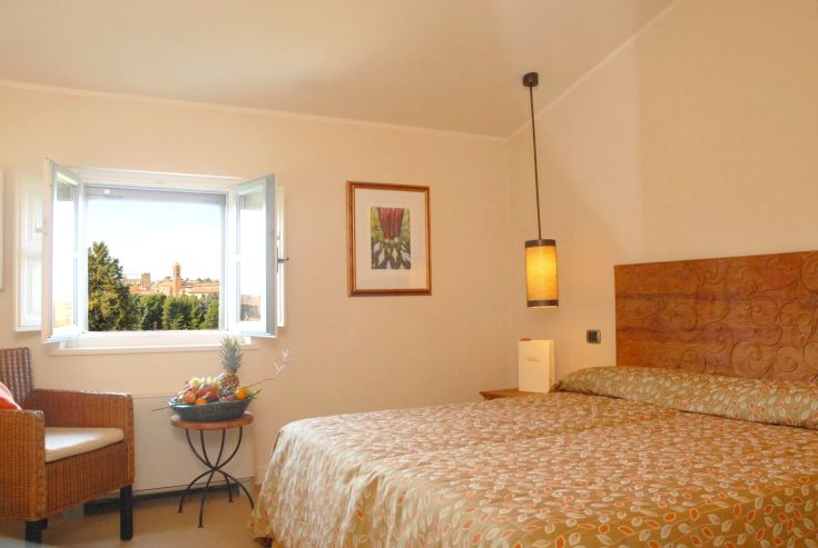 Camera confortevole con panorama del territorio circostante, dotata di arredi funzionali e accoglienti per un soggiorno sereno.