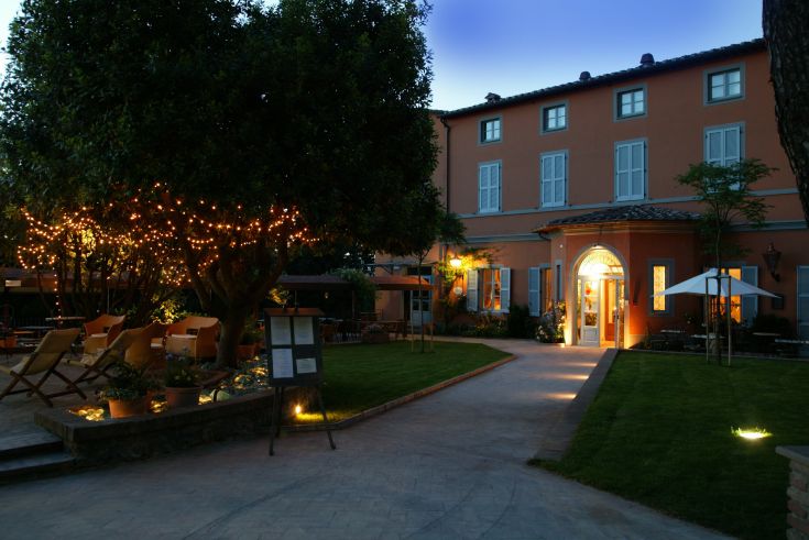 Un palazzo in Umbria, circondato da un giardino ben curato, con interni accoglienti per visite rilassanti.