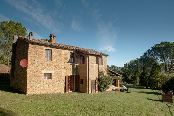 Un edificio di campagna circondato da alberi e piccoli spazi verdi, adatto per momenti di relax all'aperto.