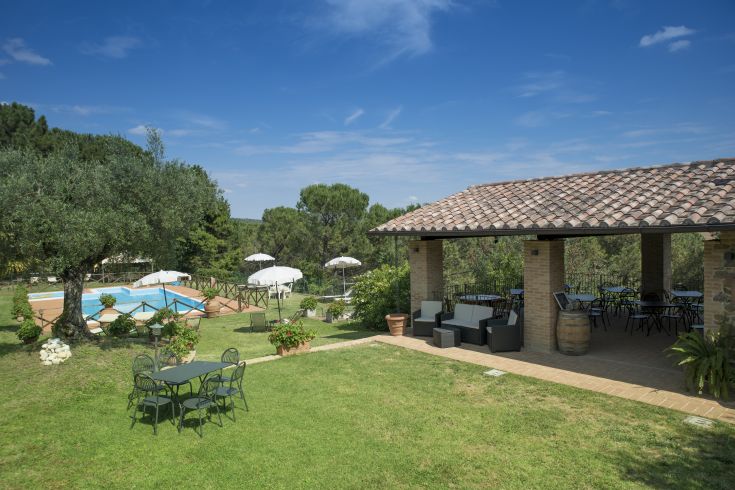 Spazio rilassante con piscina immersa nel verde e giardini ben curati, perfetto per una pausa in Umbria.