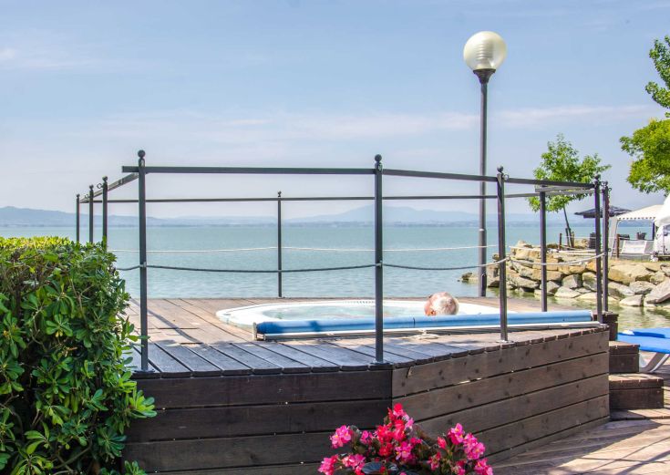 A serene area with wooden benches overlooking a lake in a natural setting.