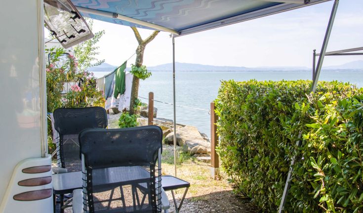 A peaceful campsite located by a lake, perfect for a relaxing vacation immersed in nature.