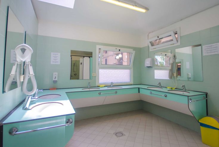 A spacious and functional bathroom featuring a sink and mirrors, in a well-kept, tidy environment.