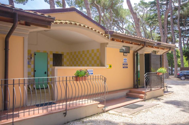 A campsite surrounded by trees, a short distance from Lake Trasimeno, with well-maintained facilities.