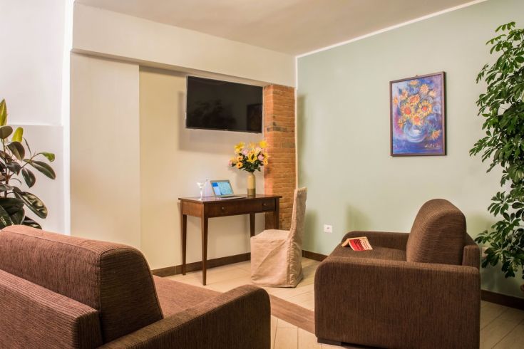 Ein einfacher Aufenthalt im Resort Isola Verde, mit Sofas und schlichten Dekorationen.