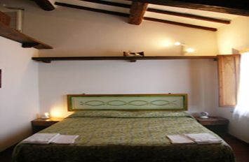 Camera confortevole con letto matrimoniale, dotata di arredi essenziali. Perfetta per un soggiorno tranquillo.