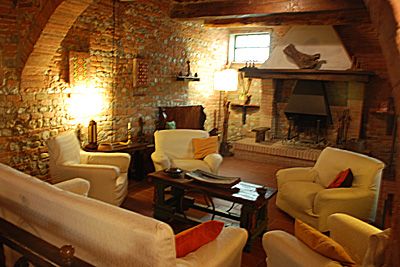 Un soggiorno accogliente presenta pareti in pietra e un camino, perfetto per momenti di tranquillità.