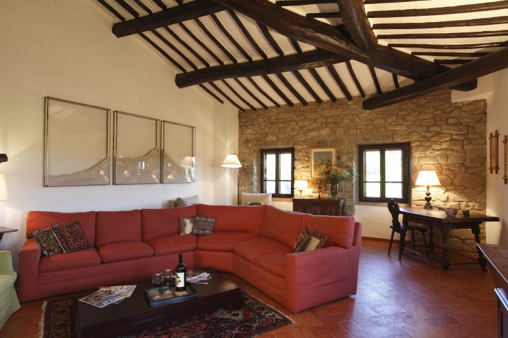 Un soggiorno accogliente con un divano rosso e finiture in pietra.