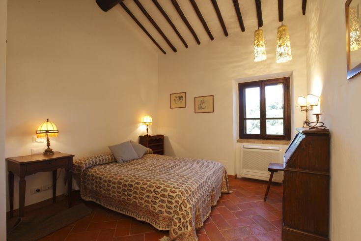 Una camera luminosa con un letto matrimoniale, arredi semplici e un'atmosfera tranquilla.