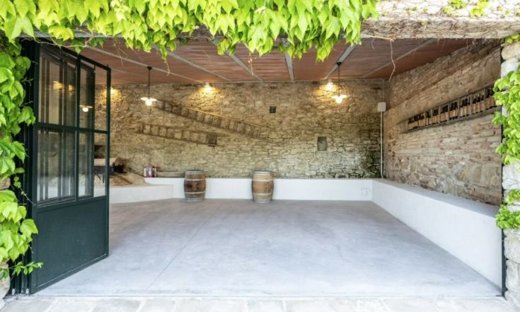 Ambiente interno semplice con pareti in pietra e legno, adatto a eventi e degustazioni.