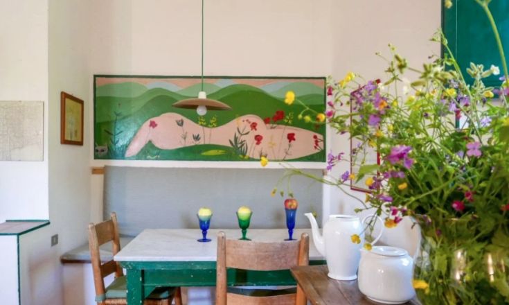Una cucina semplice con elementi decorativi colorati e fiori freschi. Uno spazio adatto per trascorrere del tempo.