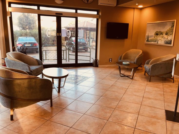 Une zone d'accueil avec des fauteuils confortables et une table basse, éclairée par de grandes fenêtres.