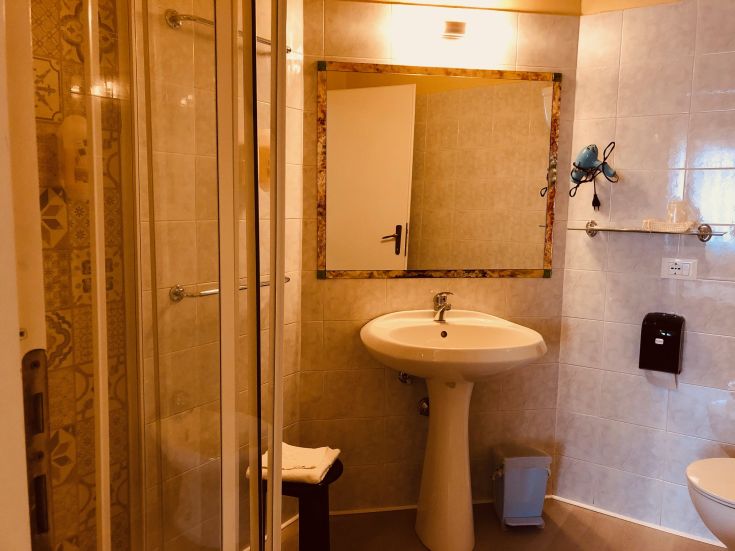 Une salle de bain contemporaine avec douche et miroir. Meublée avec des meubles pratiques et un design sobre.