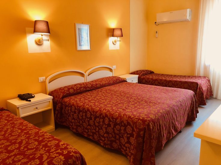 Chambre simple avec des lits doubles et simples, idéale pour un séjour relaxant.