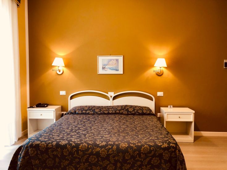 Une chambre simple et confortable avec un lit double et quelques détails décoratifs.