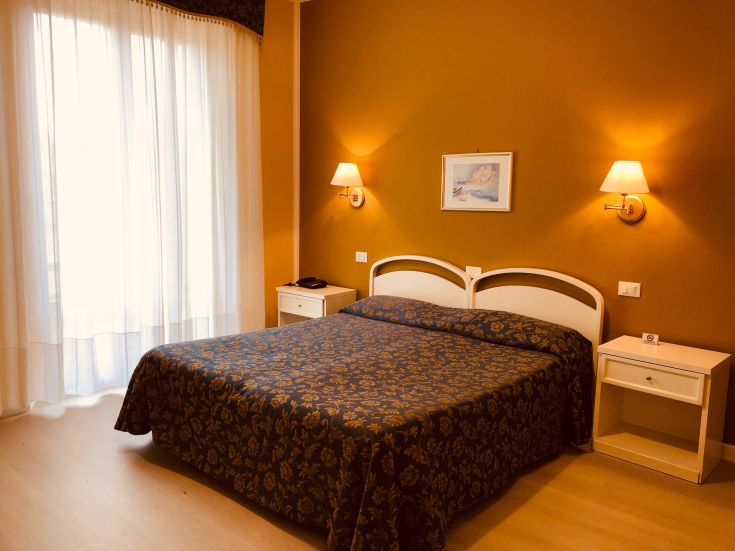 Chambre accueillante avec des meubles essentiels et lumineux, parfaite pour un séjour relaxant.