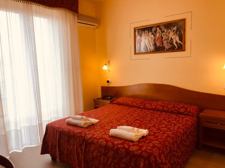 Chambre simple avec un lit double et des décorations discrètes.