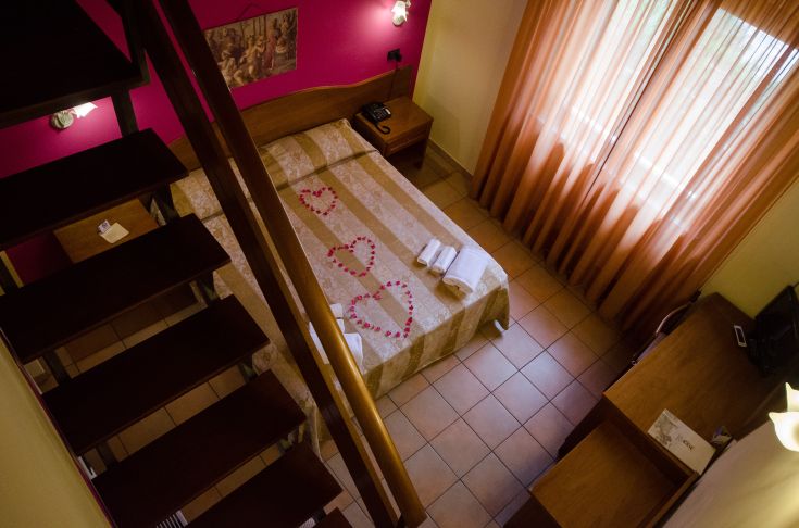 Chambre confortable avec des meubles simples et une grande fenêtre offrant une lumière naturelle.