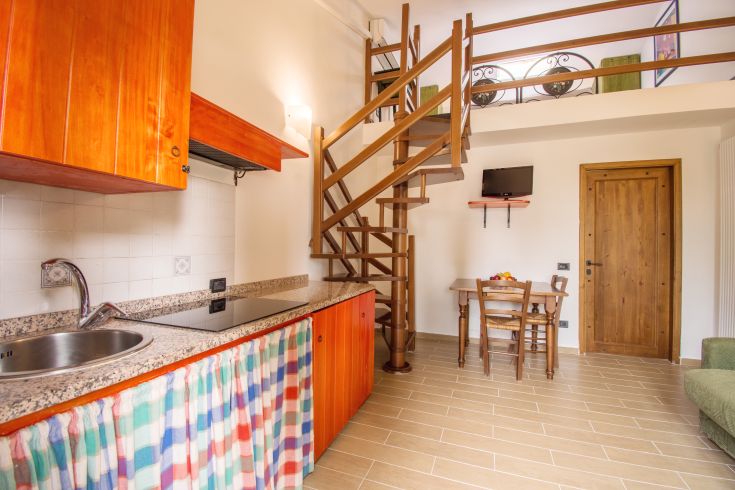 Cozy apartment with a fully equipped kitchen, spiral staircase, and dining area. Perfect for families seeking relaxation.