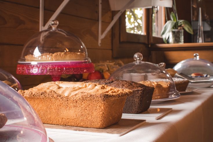 Various desserts displayed under elegant cloches in a cozy vacation home.