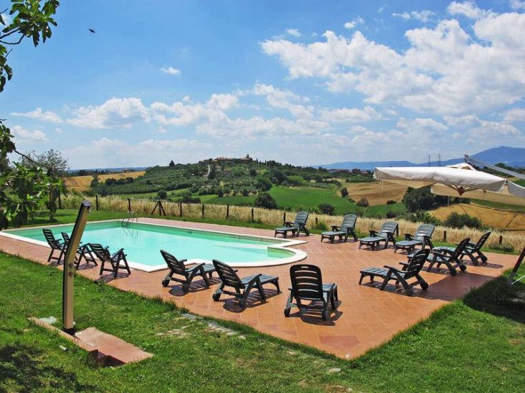 Ein Pool, der sich zwischen den umbrischen Hügeln befindet, umgeben von üppiger Vegetation und einer friedlichen Umgebung.