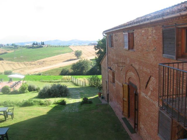 Ein ruhiger Agritourismus umgeben von Hügeln und Feldern, ideal für eine entspannende Auszeit.