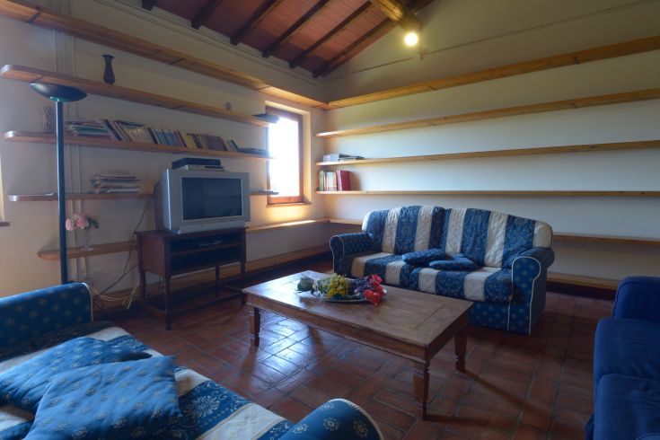 Gemütliches Wohnzimmer mit Sofas und Regalen, perfekt für Entspannungsmomente.