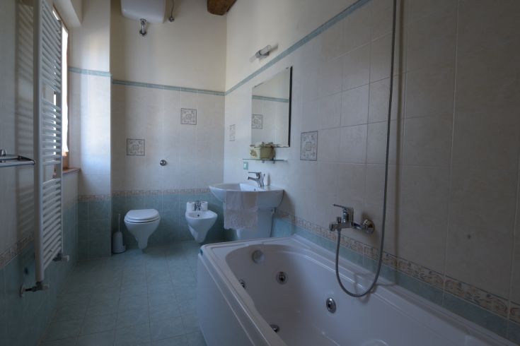 Ein geräumiges Bad mit einem Whirlpool und hellen Fliesen, ideal zum Entspannen und zur Selbstpflege.