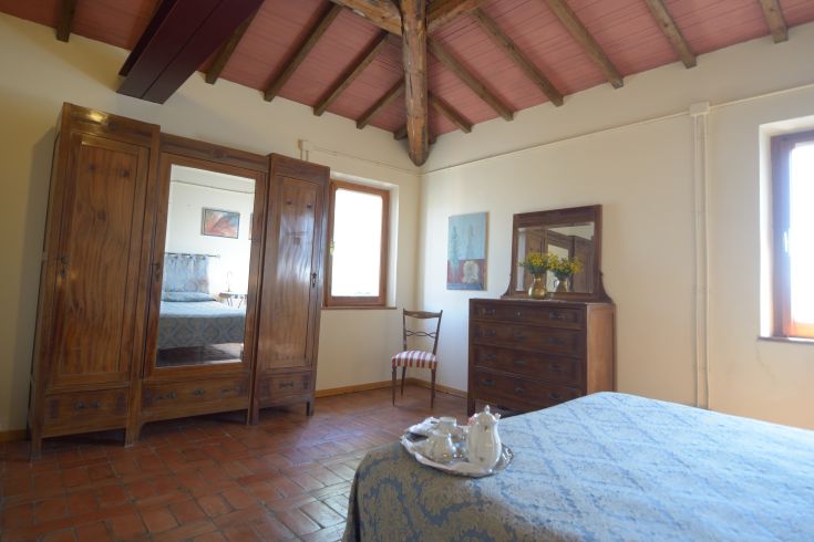 Ein einfaches Zimmer mit Holzdecken und klassischer Einrichtung, ideal für einen ruhigen Wohnbereich.