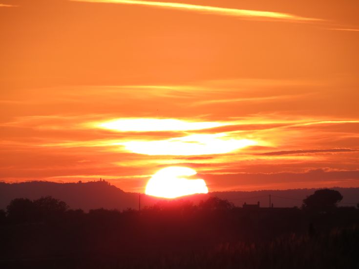 Ein Sonnenuntergang, der die umbrische Landschaft mit warmen Farbtönen im Himmel bemalt.