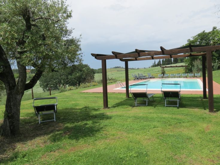 Ein ruhiger Ort, umgeben von grünen Hügeln, mit einem Pool und Bäumen. Ideal für eine entspannende Auszeit.