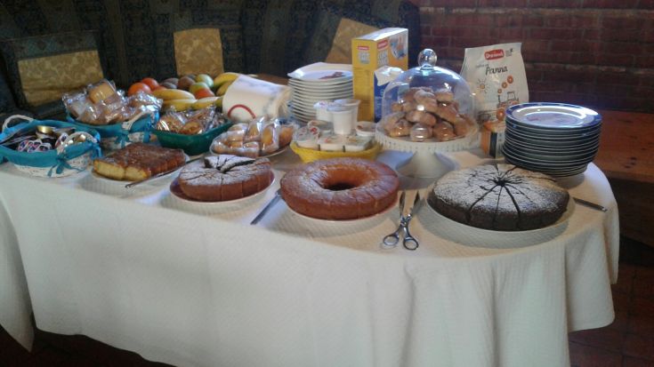 Ein Tisch gedeckt mit Gebäck, Obst und Getränken für ein einfaches, aber zufriedenstellendes Frühstück.