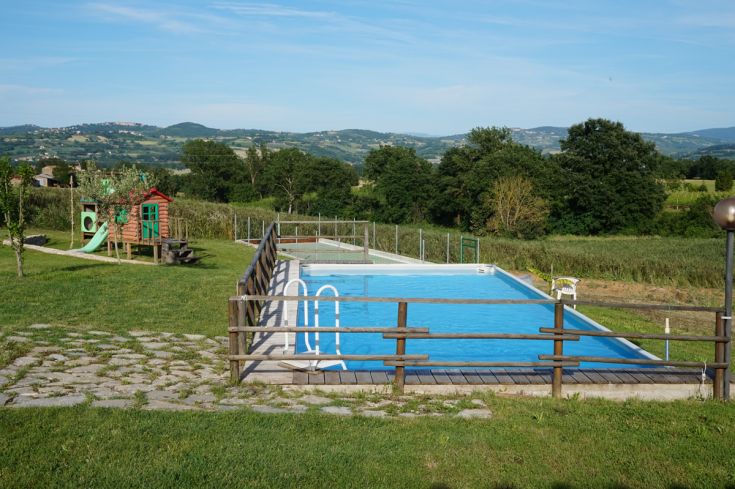 Ambiente tranquillo per il relax, dotato di piscina e area giochi nel contesto naturale dell'Umbria.