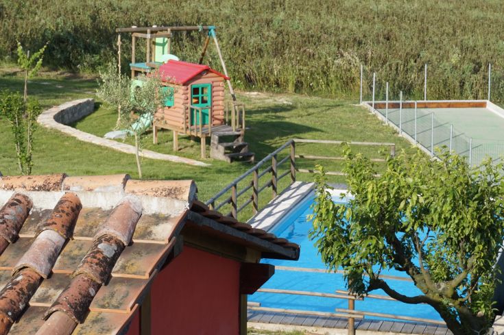 Struttura circondata da un ampio giardino, con piscina e area giochi per bambini, perfetta per il relax.