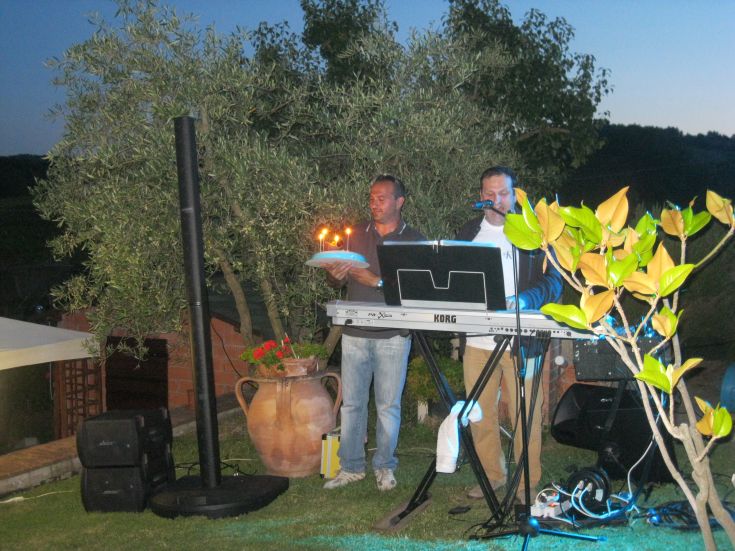 Un giardino tranquillo con musicisti che suonano mentre si gusta cibo dolce, circondati dalla vegetazione.
