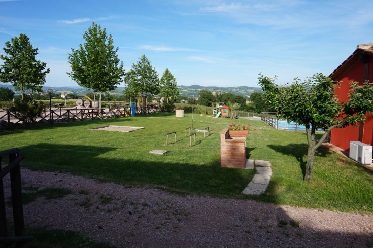 Agriturismo con ampi spazi verdi, giardino, piscina e area giochi, ideale per passeggiate nel verde.