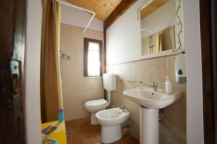 Bagno luminoso e confortevole, dotato di sanitari contemporanei e finestra che favorisce l'ingresso di luce naturale.