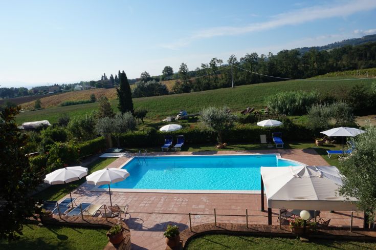 Una piscina situata in un agriturismo nella campagna umbra, circondata da uliveti e vigneti, ideale per il relax.
