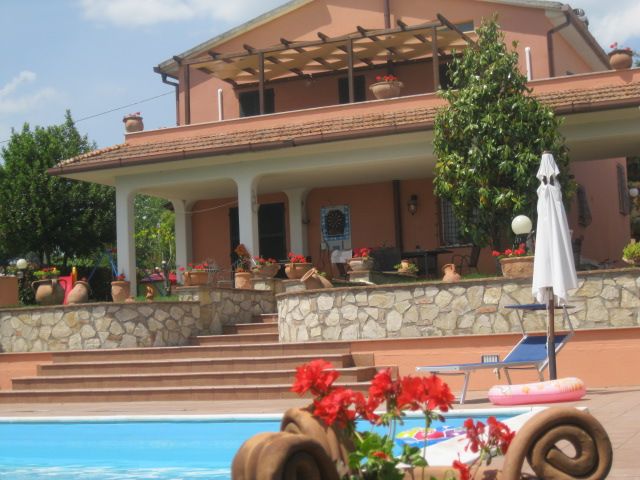 Struttura con piscina e giardino, in un contesto naturale, adatta per momenti di relax e passeggiate nel verde.