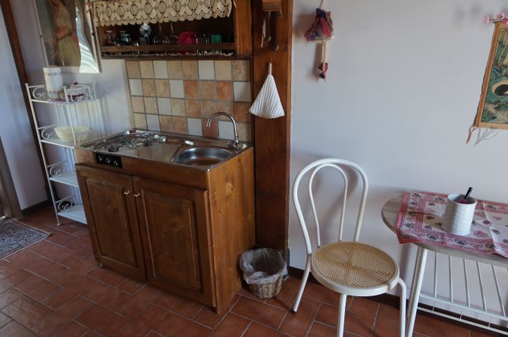 Cucina calda e accogliente, arredata con mobili in legno e particolari rustici, perfetta per convivialità.