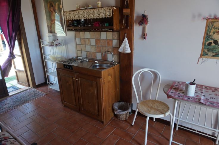 Interno di un accogliente agriturismo con cucina ben fornita e arredi in legno.