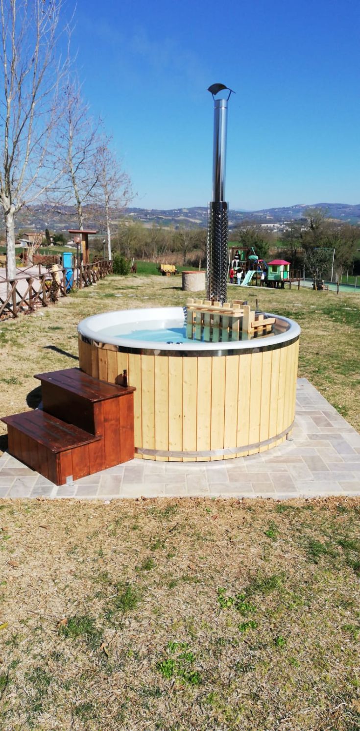 Angolo tranquillo con jacuzzi in legno, circondato dalla vegetazione tipica dell'Umbria.