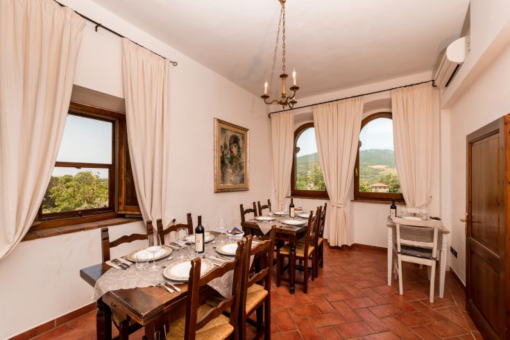 Una sala da pranzo confortevole con panorama sulla campagna, ideale per cene in compagnia.