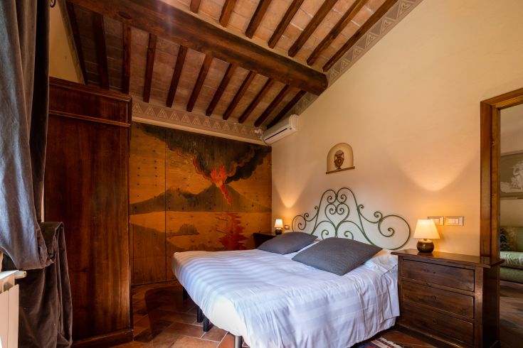 Camera accogliente con letto matrimoniale, decorata con un affresco, perfetta per un soggiorno tranquillo.