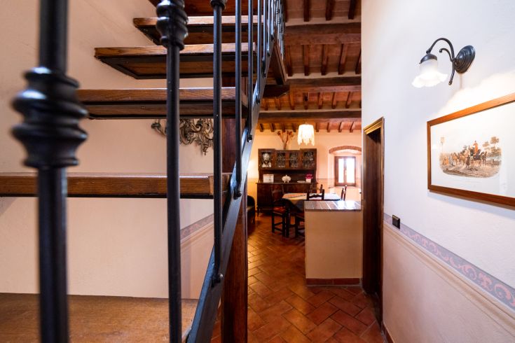 Interno di un'abitazione con scale in legno e elementi rustici, creando un'atmosfera accogliente.