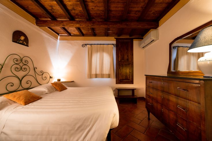 Una camera semplice con letti comodi, mobili in stile tradizionale e alcuni dettagli decorativi.