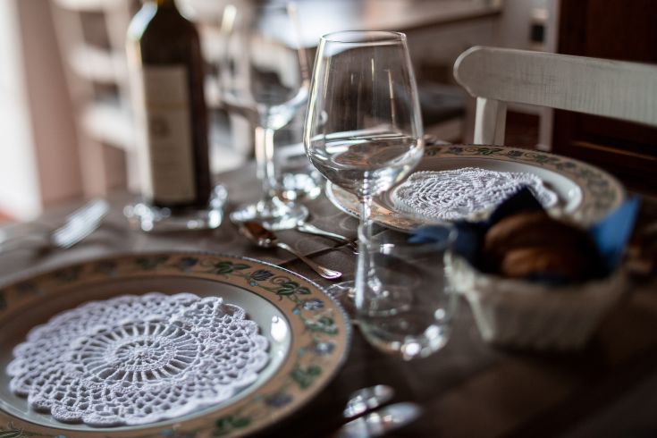 Tavola semplicemente apparecchiata con piatti e bicchieri disposti in modo ordinato, pronta per un pasto.